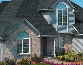 Exterior of a home with charcoal black asphalt shingles on its roof