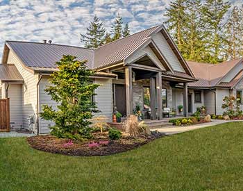 Front view of a home with a rust colored metal roof system by Westform Metals