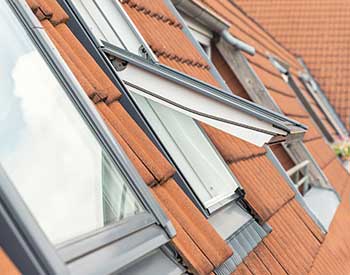 Close up of VELUX skylights on a residential roof with orange clay tiles